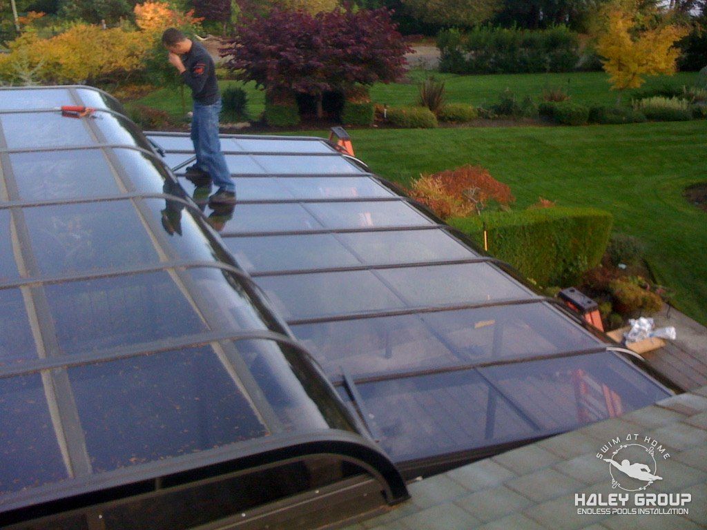 Installer working on a curved-eave glass sunroom roof