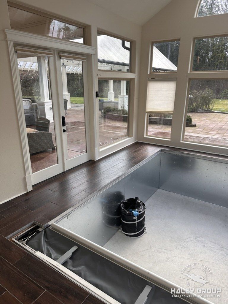 Assembled pool shell with tile floor running flush to the coping