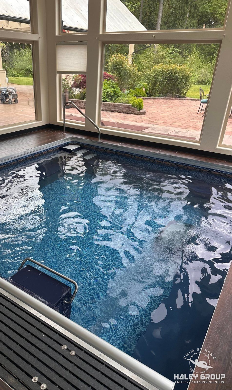 Indoor Endless Pool in a glass-walled room overlooking a garden patio, Maple Valley, WA