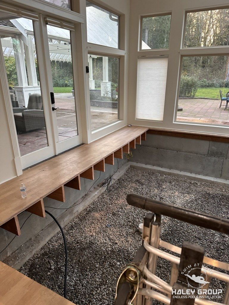 Sunroom floor opened down to the crawlspace, with a temporary bench along the window wall
