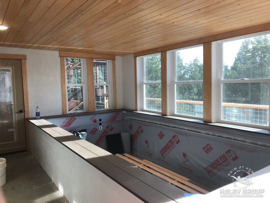 Pool shell framed and wrapped during construction, under a tongue-and-groove wood ceiling