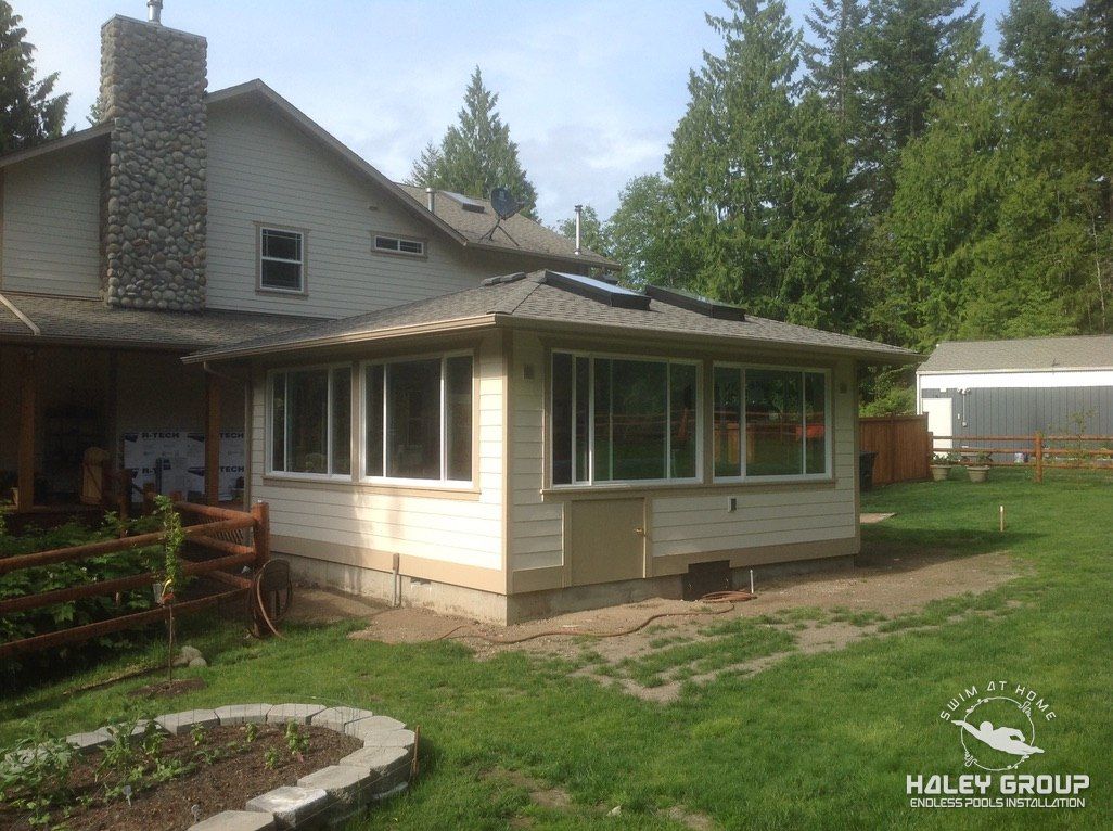 Hip-roof sunroom addition with skylights and walls of windows
