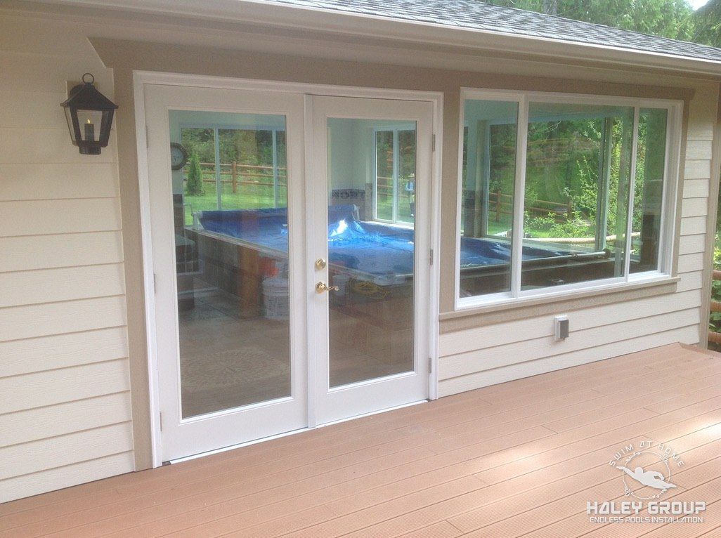 French doors onto the deck, with the covered pool visible inside